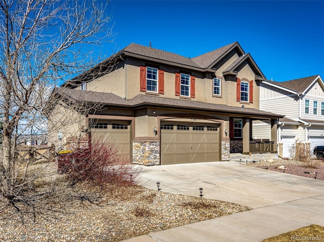 view of front of home with a garage, stone siding, driveway, and stucco siding