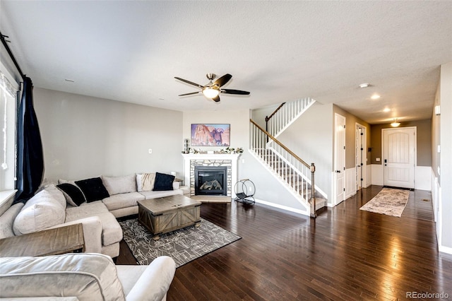 living area with wood-type flooring, stairs, baseboards, and a fireplace