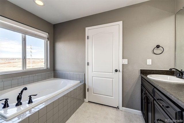 full bath with vanity, baseboards, and a bath