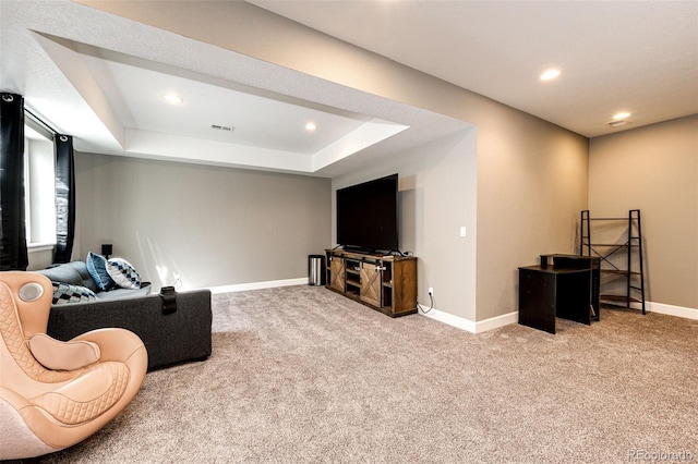 carpeted living area featuring a tray ceiling, recessed lighting, visible vents, and baseboards