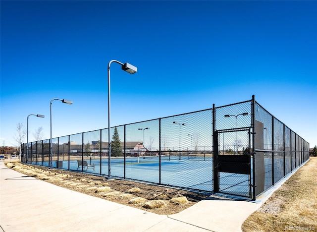 view of sport court with fence and a gate