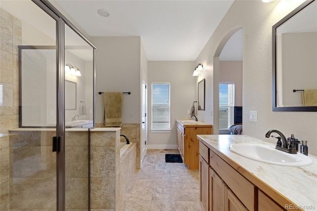 bathroom with vanity and shower with separate bathtub