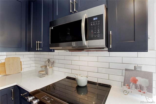 5555 E Briarwood Ave Unit 603, Centennial, CO 80122 - kitchen featuring stainless steel microwave, blue cabinets, stove, and tasteful backsplash