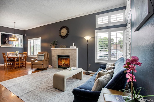 5555 E Briarwood Ave Unit 603, Centennial, CO 80122 - living area with ornamental molding, wood finished floors, a textured ceiling, and a fireplace