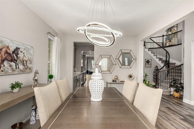 5964 E 141st Ave, Thornton, CO 80602 - dining area featuring a chandelier, stairway, wood finished floors, and baseboards
