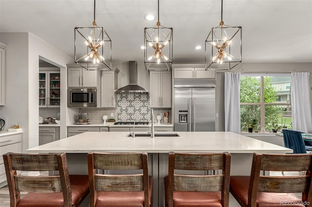 5964 E 141st Ave, Thornton, CO 80602 - kitchen featuring built in appliances, wall chimney exhaust hood, gray cabinets, a sink, and decorative backsplash