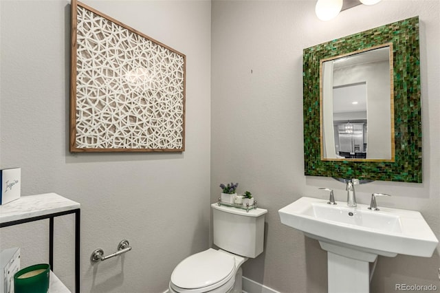 5964 E 141st Ave, Thornton, CO 80602 - half bathroom featuring toilet, a sink, and baseboards