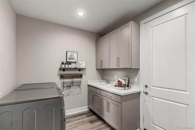 5964 E 141st Ave, Thornton, CO 80602 - laundry room featuring washing machine and dryer, cabinet space, baseboards, light wood-type flooring, and recessed lighting