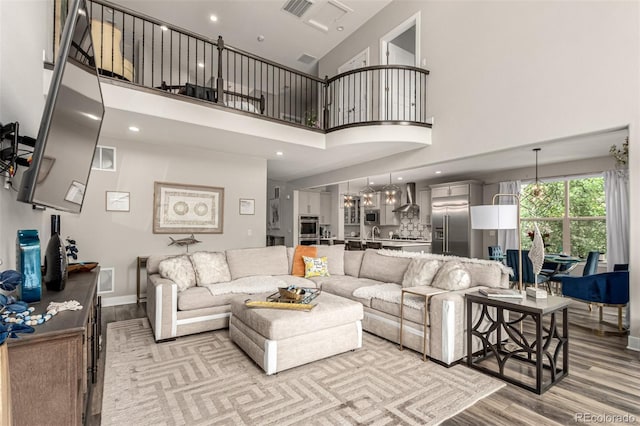 5964 E 141st Ave, Thornton, CO 80602 - living area with wood finished floors, a high ceiling, and recessed lighting