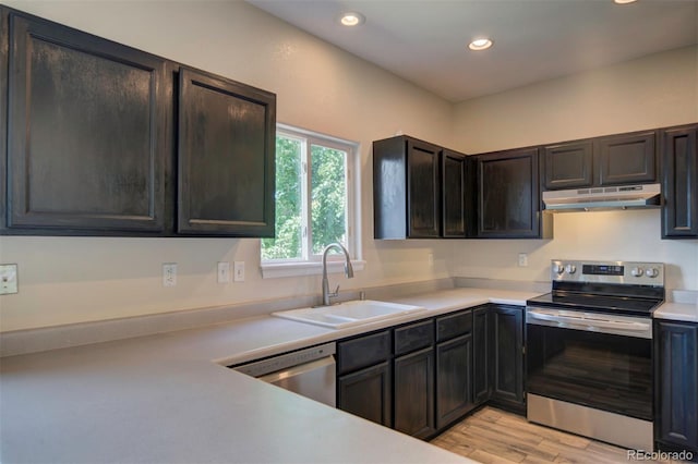 12535 S Beaver Creek Way, Parker, CO 80134 - kitchen with appliances with stainless steel finishes, under cabinet range hood, recessed lighting, light countertops, and light wood-style floors