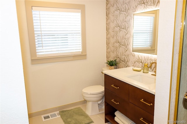 bathroom featuring tile patterned floors, vanity, toilet, and a wealth of natural light