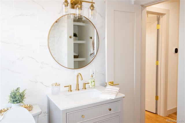 bathroom with vanity, wood-type flooring, tile walls, and toilet