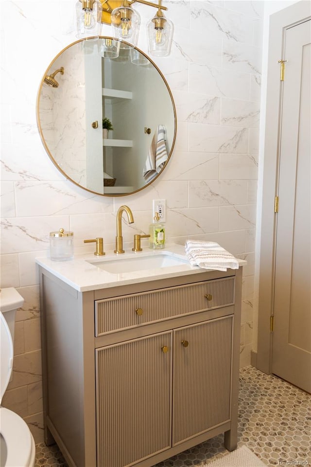 bathroom with vanity, tile walls, and toilet