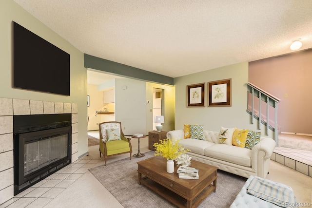 carpeted living room with a tile fireplace and a textured ceiling