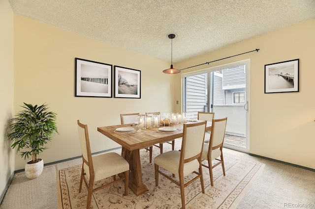 carpeted dining room with a textured ceiling