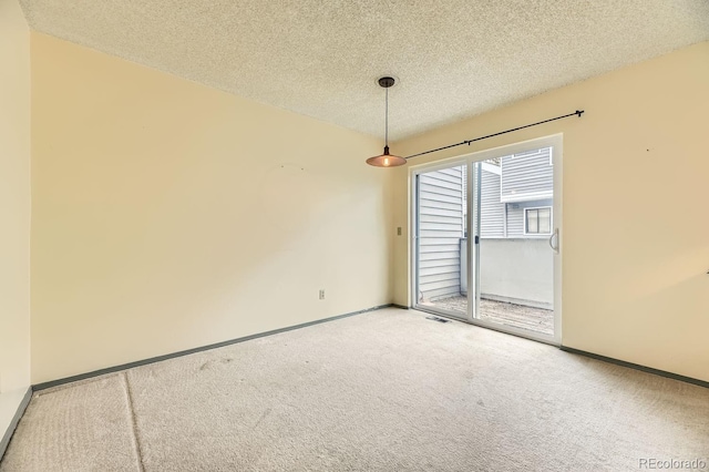 empty room featuring carpet and a textured ceiling