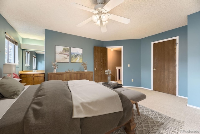 bedroom with carpet flooring, ceiling fan, and a textured ceiling