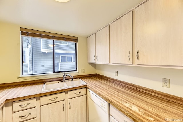 kitchen with light brown cabinetry, dishwasher, and sink