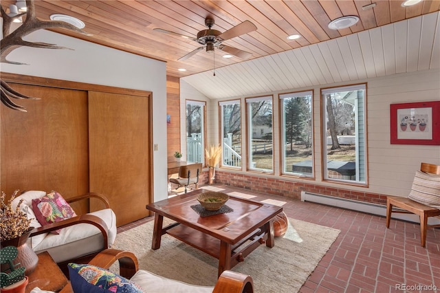 sunroom / solarium featuring lofted ceiling, baseboard heating, wood ceiling, and a ceiling fan