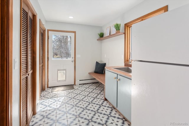 interior space featuring a sink, recessed lighting, light floors, and a baseboard radiator