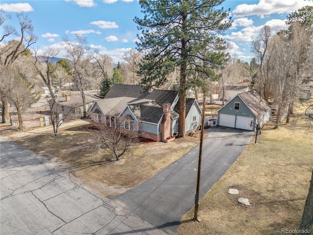 view of front of home featuring aphalt driveway, a garage, a front lawn, and an outdoor structure