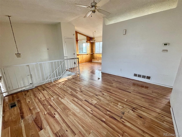 spare room featuring hardwood / wood-style floors, ceiling fan, a textured ceiling, and vaulted ceiling