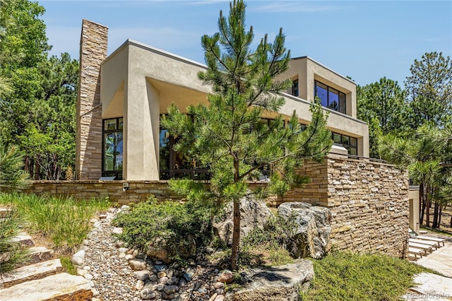 1250 Dolan Dr, Monument, CO 80132 - view of front facade with stucco siding and a chimney