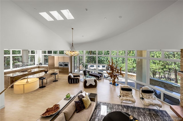 1250 Dolan Dr, Monument, CO 80132 - living room featuring high vaulted ceiling, a skylight, wood finished floors, and healthy amount of natural light