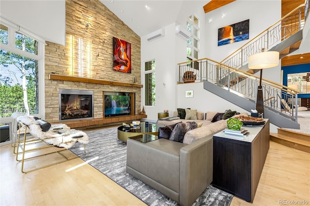 1250 Dolan Dr, Monument, CO 80132 - living area featuring high vaulted ceiling, wood finished floors, stairway, a stone fireplace, and recessed lighting