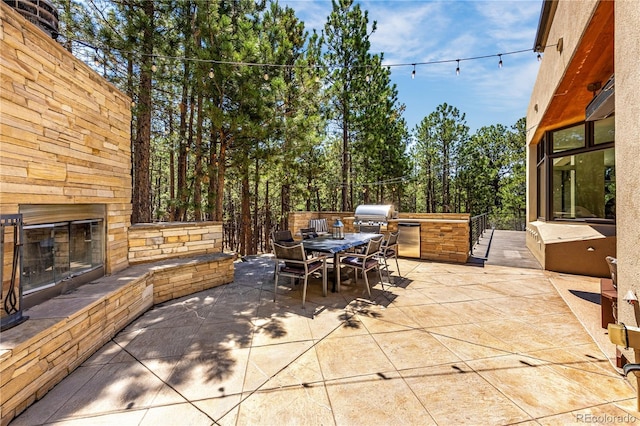 1250 Dolan Dr, Monument, CO 80132 - view of patio with an outdoor stone fireplace, area for grilling, and outdoor dining area