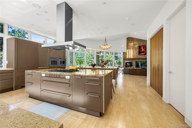 1250 Dolan Dr, Monument, CO 80132 - kitchen featuring island range hood, light wood-type flooring, appliances with stainless steel finishes, modern cabinets, and healthy amount of natural light