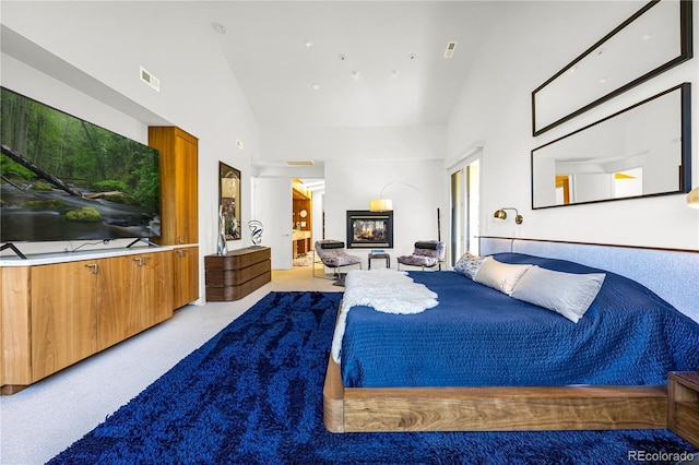1250 Dolan Dr, Monument, CO 80132 - carpeted bedroom featuring high vaulted ceiling and a glass covered fireplace