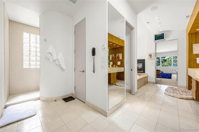 1250 Dolan Dr, Monument, CO 80132 - bathroom featuring a multi sided fireplace, vanity, a garden tub, tile patterned floors, and walk in shower