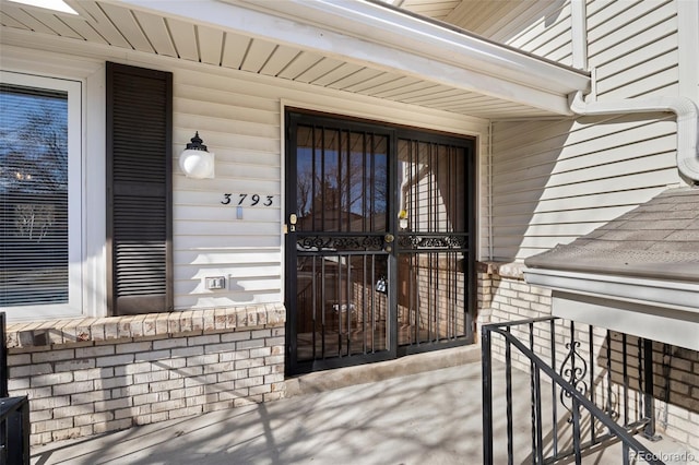 property entrance featuring brick siding