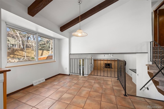 interior space featuring visible vents, lofted ceiling with beams, baseboards, and light tile patterned flooring