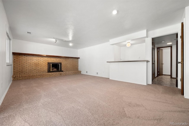 unfurnished living room with carpet flooring, a fireplace, and visible vents