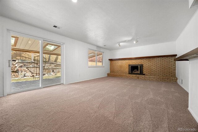 unfurnished living room featuring carpet, a fireplace, and visible vents