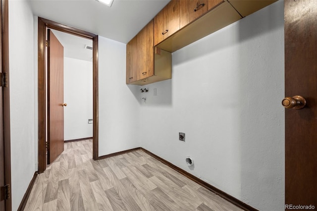 laundry room featuring cabinet space, hookup for an electric dryer, light wood-style flooring, and baseboards