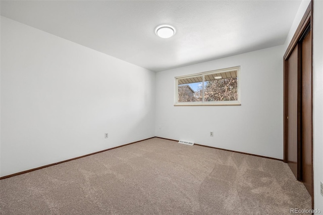 unfurnished bedroom featuring carpet floors, a closet, visible vents, and baseboards