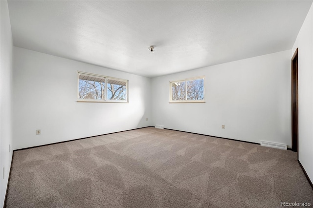 empty room featuring light colored carpet and visible vents