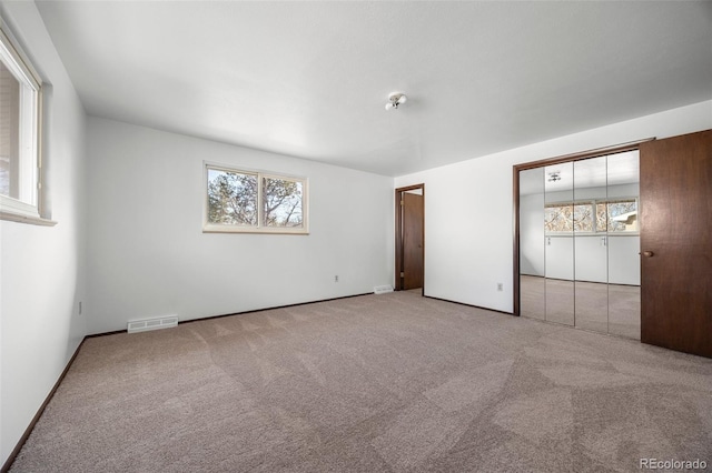 unfurnished bedroom with visible vents and light colored carpet