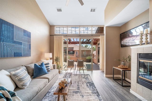 8626 Gold Peak Dr Unit B, Highlands Ranch, CO 80130 - living room with wood finished floors, ceiling fan, a fireplace, and a towering ceiling