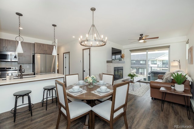 361 Gcr 840 Unit 3, Fraser, CO 80442 - dining space with dark wood finished floors, a ceiling fan, a glass covered fireplace, and a chandelier