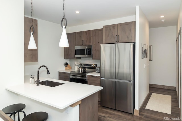 361 Gcr 840 Unit 3, Fraser, CO 80442 - kitchen featuring appliances with stainless steel finishes, dark wood-style flooring, a breakfast bar, light countertops, and tasteful backsplash