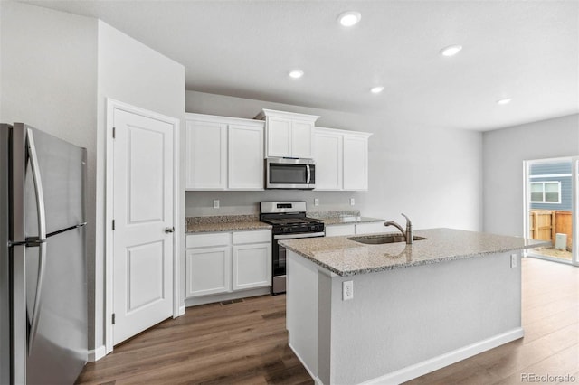 kitchen featuring white cabinets, sink, appliances with stainless steel finishes, and an island with sink