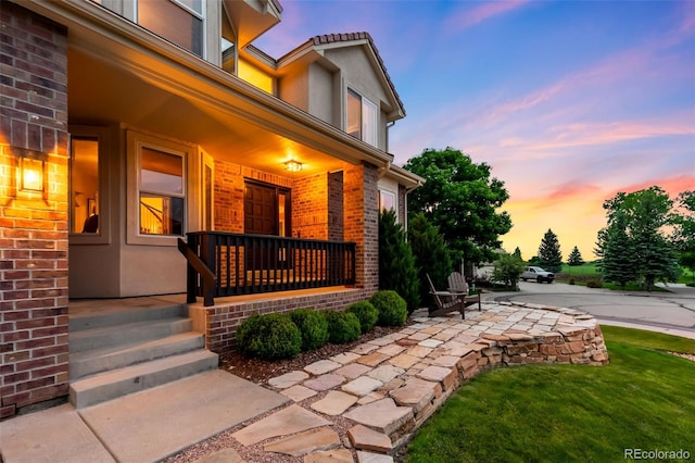 7038 Russell Ct, Arvada, CO 80007 - property entrance featuring covered porch, brick siding, and stucco siding