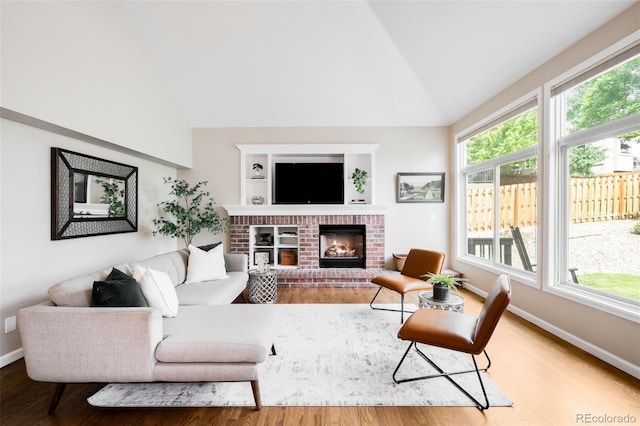 7038 Russell Ct, Arvada, CO 80007 - living room featuring wood finished floors, a fireplace, baseboards, and high vaulted ceiling