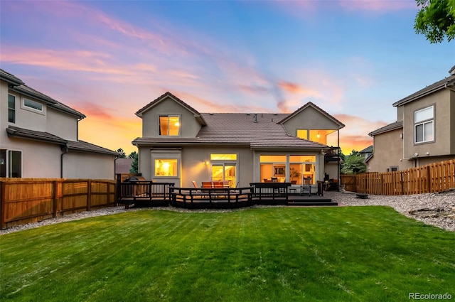 7038 Russell Ct, Arvada, CO 80007 - back of house at dusk with a tile roof, a wooden deck, and stucco siding
