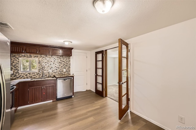 4730 S Huron St, Englewood, CO 80110 - kitchen featuring appliances with stainless steel finishes, french doors, wood finished floors, backsplash, and a textured ceiling