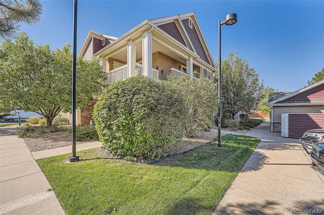 view of side of home featuring a balcony, a garage, and a yard